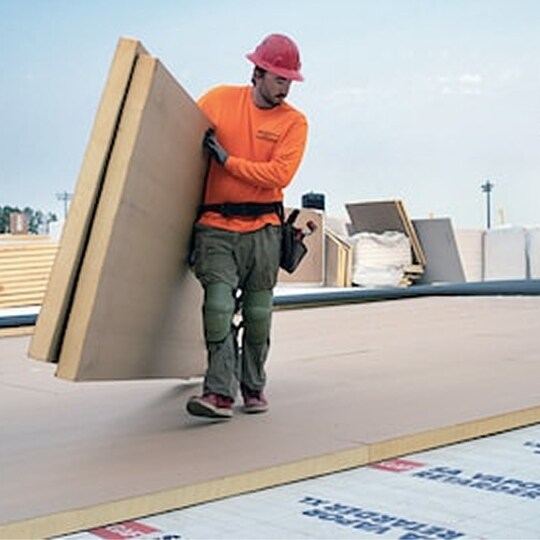 GAF Energy employee installing flat roof insulation