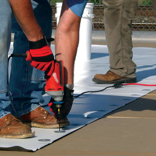 A GAF certified contractor using a power driver to mechanically secure PVC roofing plates and fasteners.