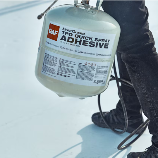 A GAF certified contractor carrying a portable canister of GAF EverGuard TPO QuickSpray Adhesive.