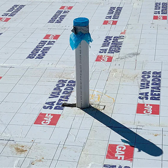 Pipe penetration flashed through a GAF SA Vapor Retarder membrane on a commercial roof deck.