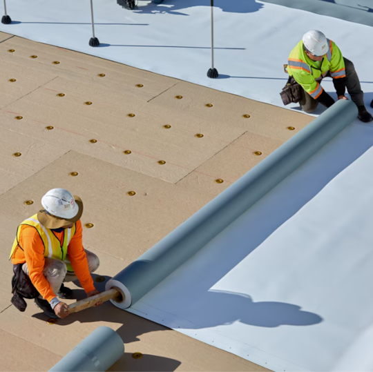 GAF certified contractors installing single-ply roof membrane attachment systems on a commercial roof.