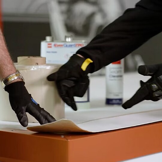 A GAF certified contractor applying EverGuard TPO Primerless Cover Tape to a roof edge detail.