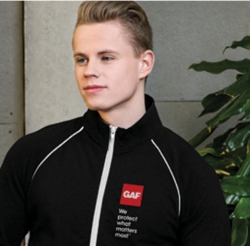 Young man wearing a premium GAF branded black zip up sold on GAF StoreFont