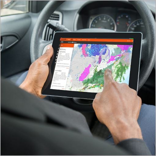 GAF certified contractor using GAF WeatherHub on a tablet in vehicle.