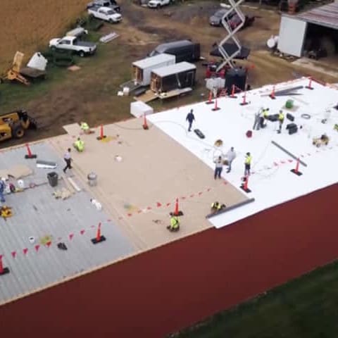 GAF contractors on top of commercial roof installing a metal retrofit