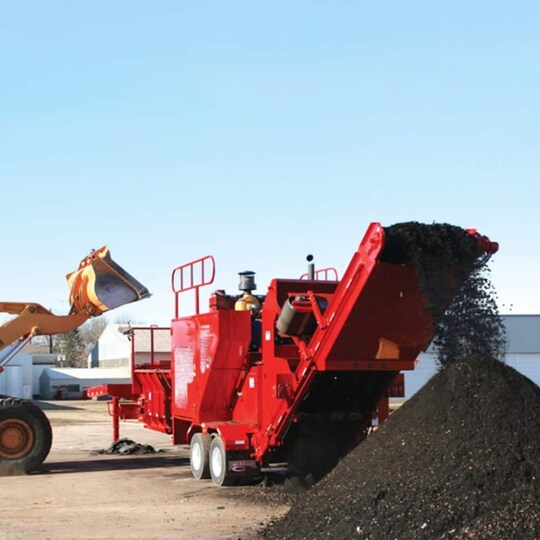 GAF roofing using machinery to recycle asphalt shingles.