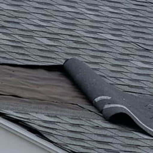 Wind damage to roof on home with gray shingles