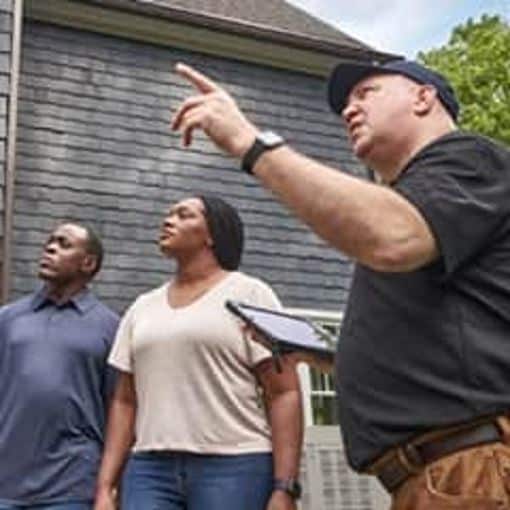 GAF certified contractor reviewing roof with homeowners