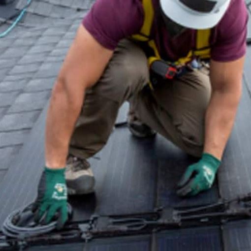 Roofing contractor installing solar roof shingles