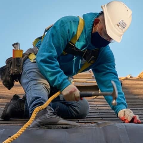 GAF Certified contractor fixing shingles on a roof