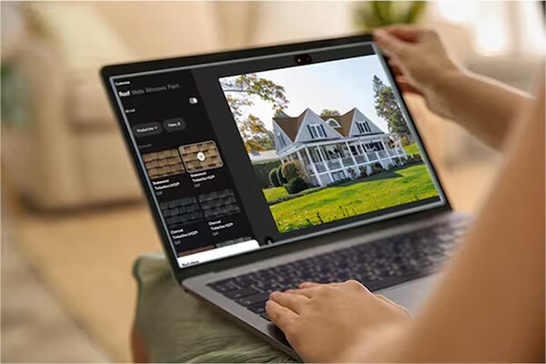 Homeowner’s hands on a laptop while using GAF’s Virtual Home Remodeler to see how GAF shingles will look on a house. 