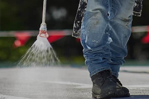 Contractor spraying commercial roof with GAF Acrylic Protective Coatings.