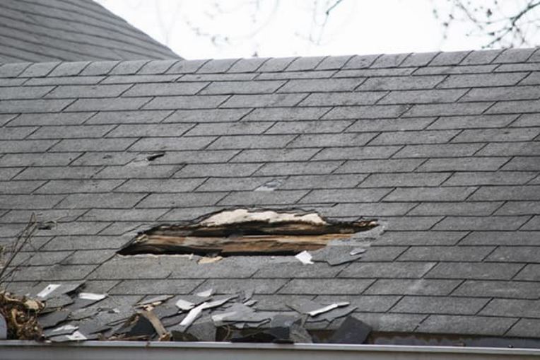 Roof with hole after hurricane damage