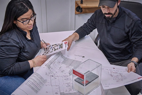 A GAF certified commercial contractor reviewing plans and roof assembly with a colleague.