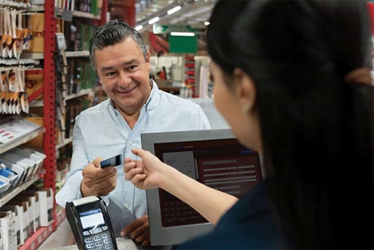 Man handing woman credit card in store