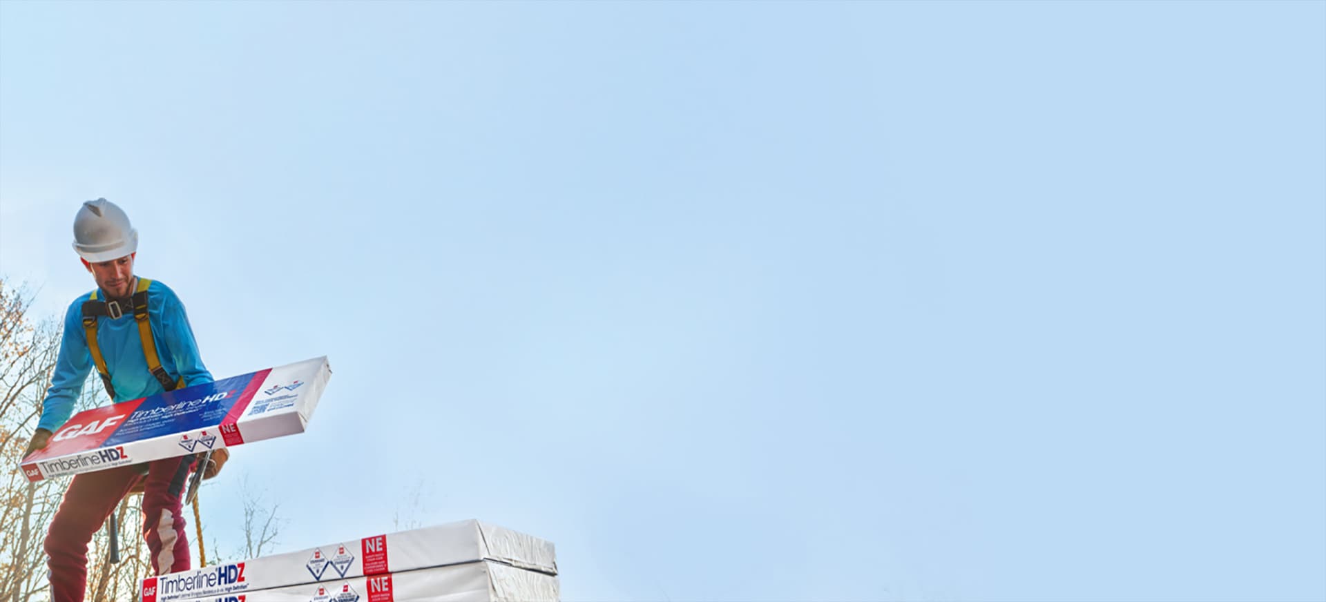 GAF certified residential roofing contractor holding package of Timberline HDZ shingles