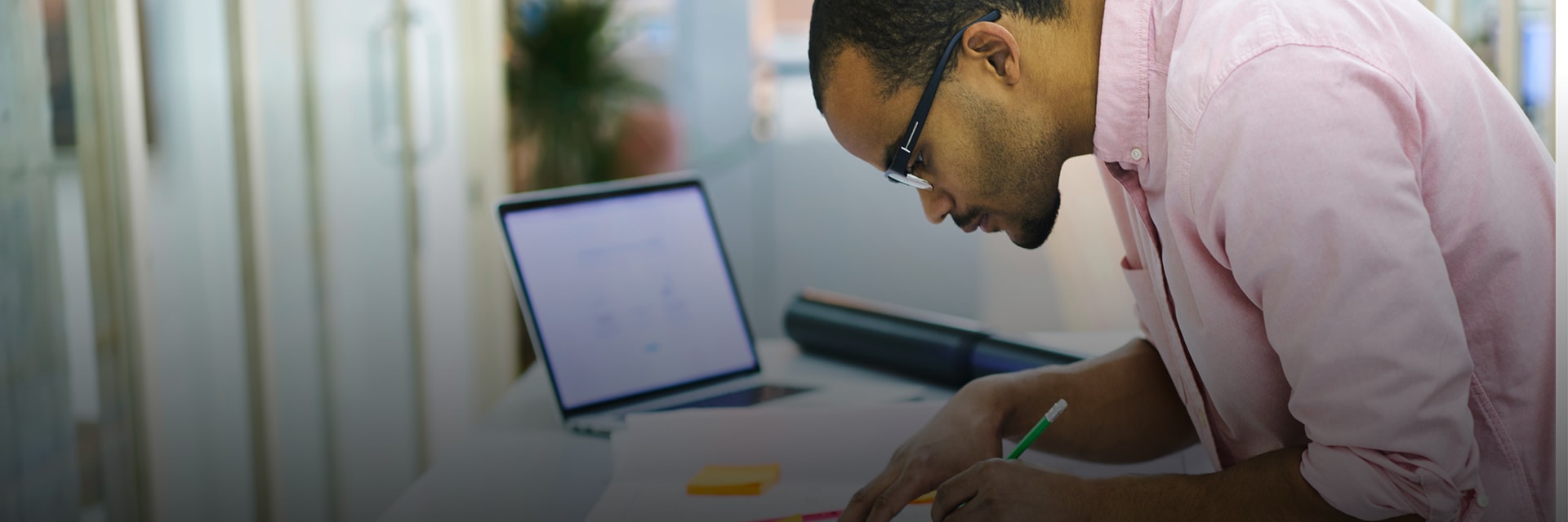 Architect reviewing roofing specification documents near open laptop