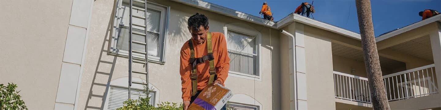 Roof contractors repairing a roof that was damaged by a hurricane