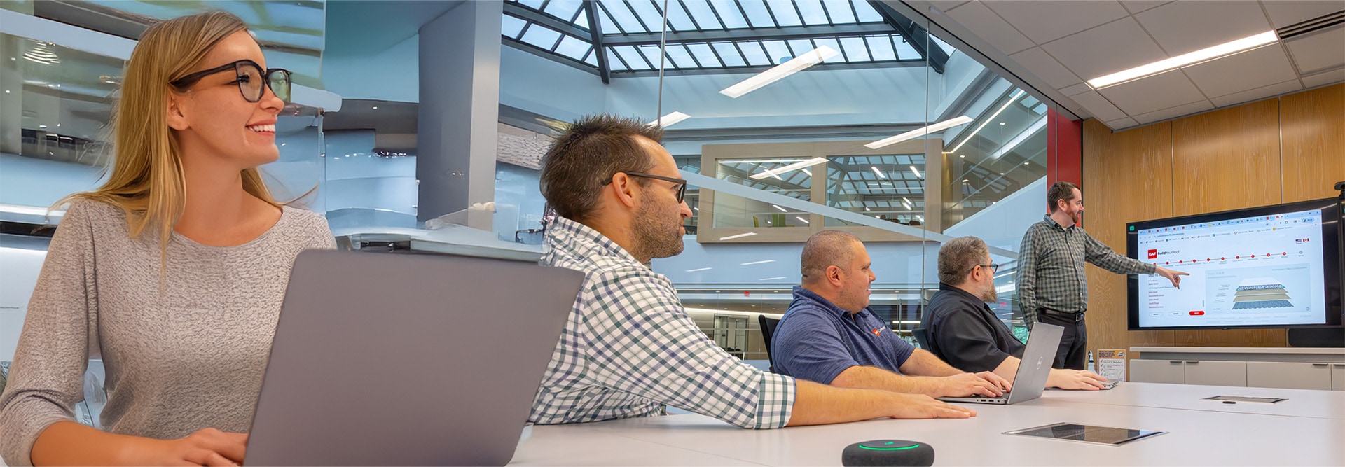 GAF Design Services team reviewing roofing specs in a conference room.