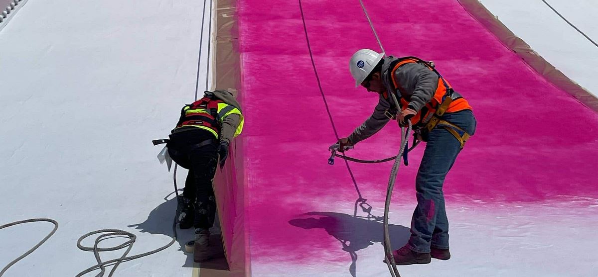 Workers spraying GAF Hydrostop coating on Circus Circus roof