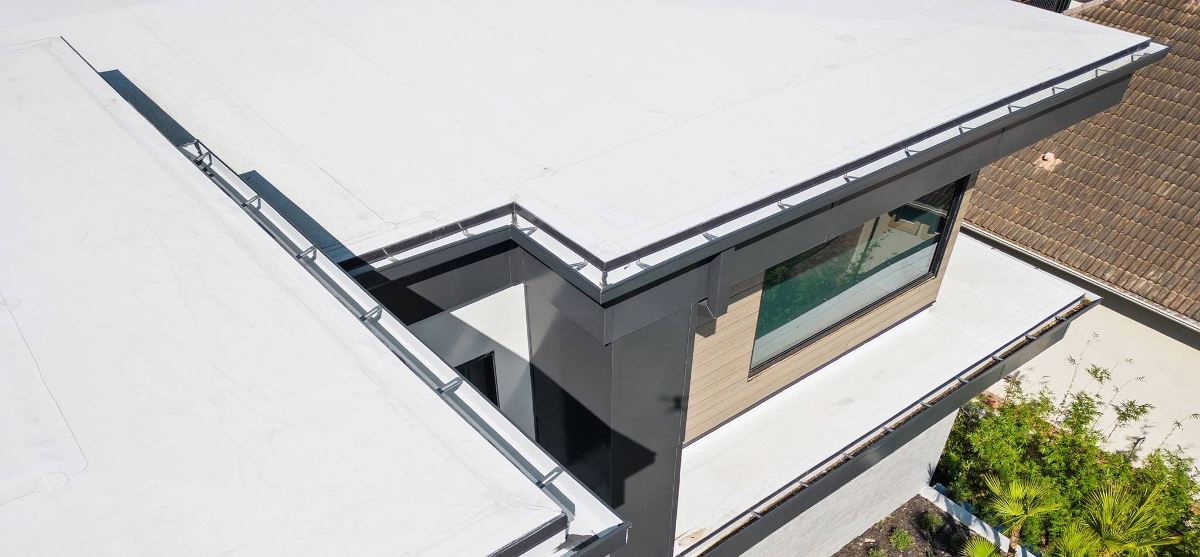 Levels of a flat roof home with GAF TPO membrane and accessories