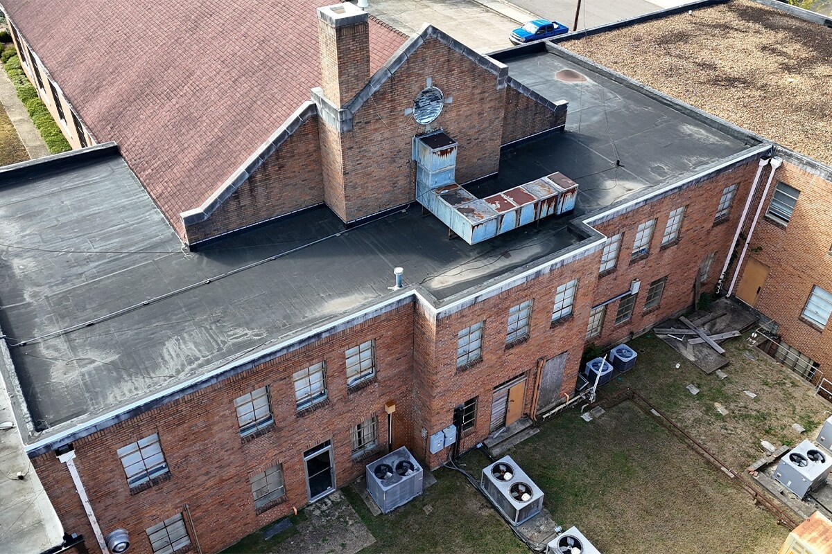 Before image of the aging roofs with varying flat roof materials at the Link Centre in Tupelo, MS.