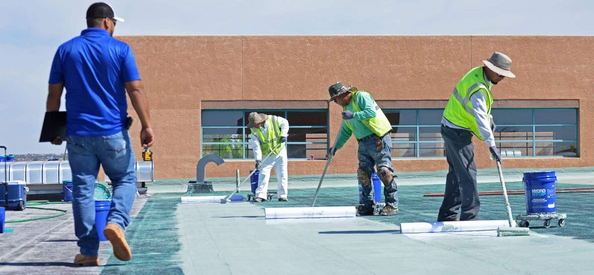 Roofing Contractors applying GAF roof coatings on Santa FE Community college roof