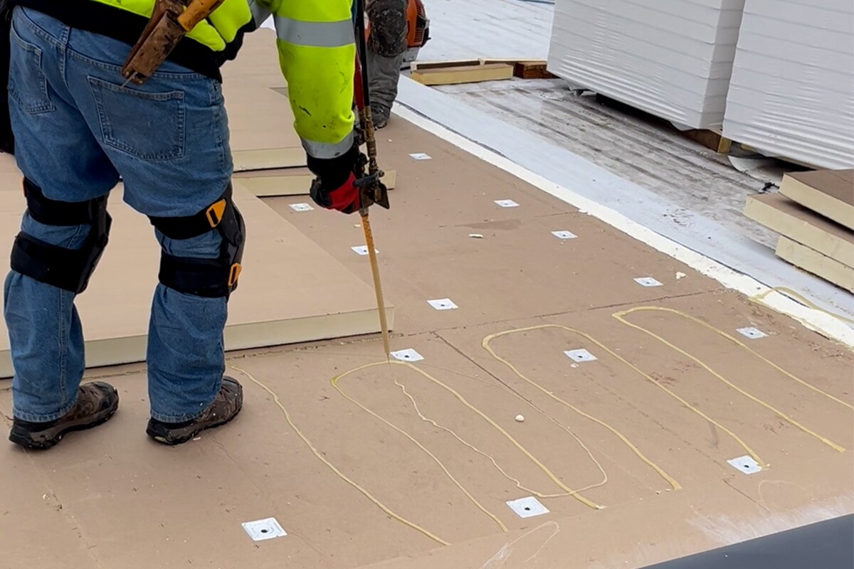 Roofing contractors working on the roof of the Wisconsin Saputo Cheese facility