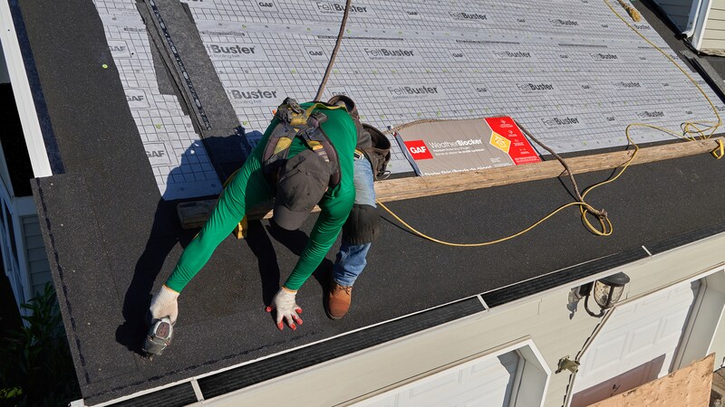Roofer nailing WeatherBlocker to a residential roof