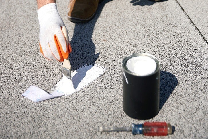 Contractor applying coating with a brush