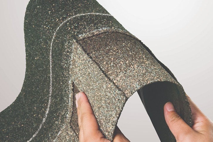 Hands bending a strip of Timberline ArmorShield II shingles, showing how flexible and durable it is.