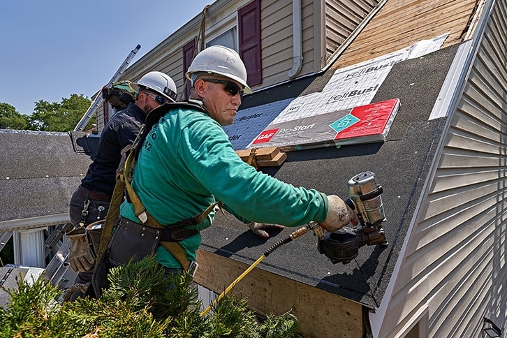 GAF certified roofing contractors installing starter strip shingles.
