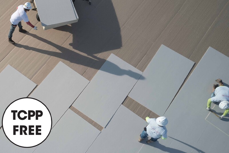 Three GAF contractors laying down and aligning TCPP-free NH polyiso products with TCPP icon on top of image