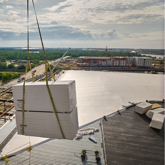 A construction site erecting a new building using details and designs from the GAF Building and Roofing Science team