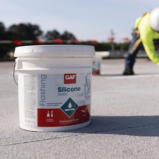 A container of GAF Silicone Mastic on a flat roof