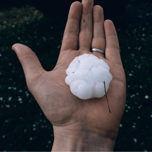 Hand holding very large piece of hail