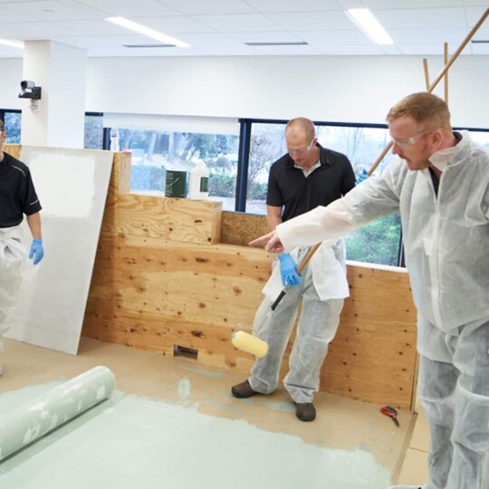 Inmates learning valuable roofing skills from GAF roofing academy.