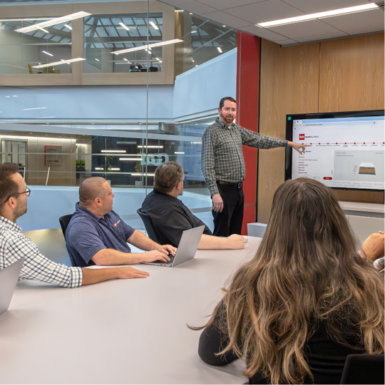 GAF Design Services team reviewing roofing specs in a conference room.