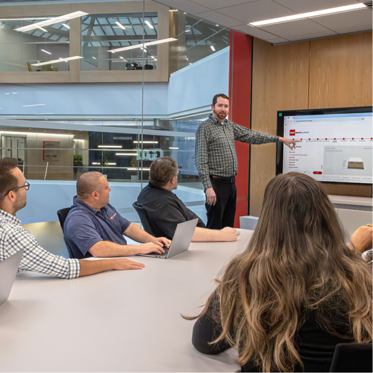GAF Design Services team reviewing roofing specs in a conference room.