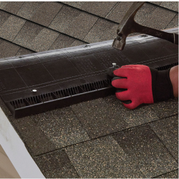 Contractor nailing ventilation onto new roof with GAF shingles