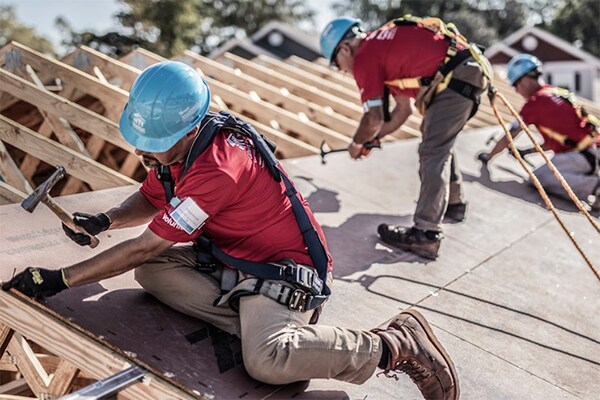 Professional contractors work on a roof using roofing materials donated by GAF. 