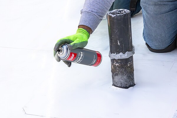 Close up of contractor spraying EverGuard® TPO Primer onto a commercial roof.