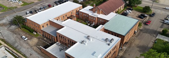 Aerial view of Link Centre complex in Tupelo, MS with different flat roof materials, all restored with GAF High Solids Silicone.