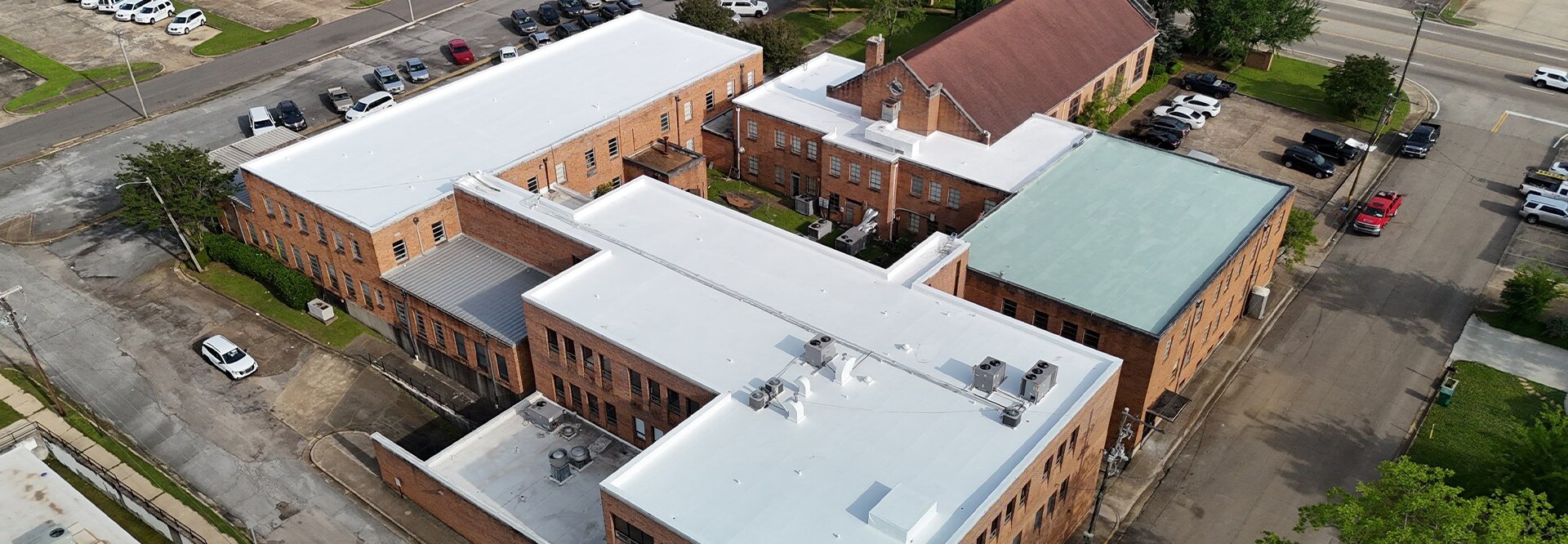 Aerial view of Link Centre complex in Tupelo, MS with different flat roof materials, all restored with GAF High Solids Silicone.