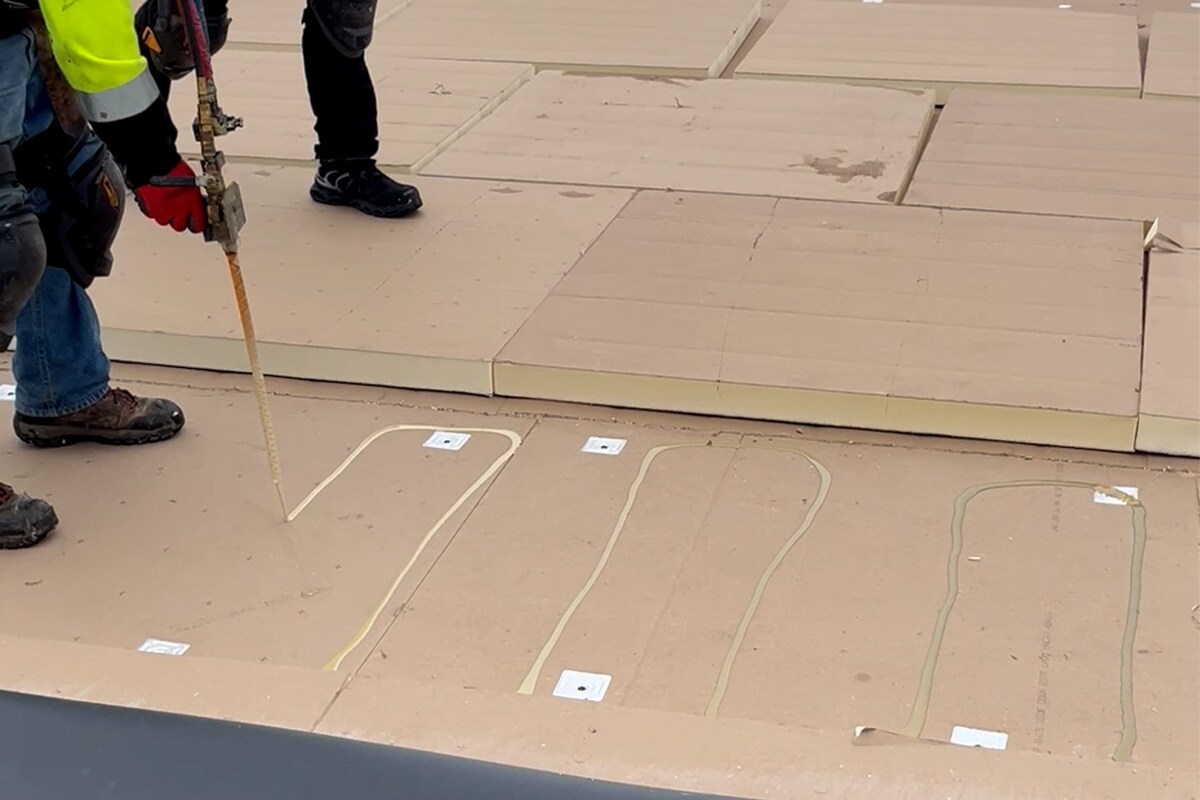 Roofing contractors working on the roof of the Wisconsin Saputo Cheese facility
