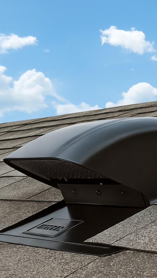 Sideview of a black Master Flow Bath and Dryer Vent from GAF on a brown shingled rooftop