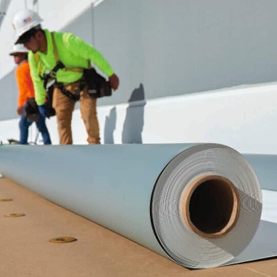 GAF employees with rolls of roofing materials