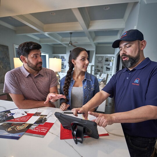 Roofing contractor educating homeowners on how to plan for their roof replacement.